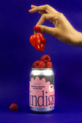 Load image into Gallery viewer, A can of Indigo soda with raspberries and a habanero on top, on a blue background.

