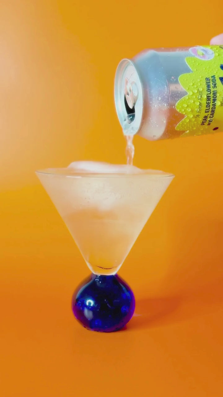 Pouring pear elderflower and cardamom soda, the soda is bubbling and fizzing